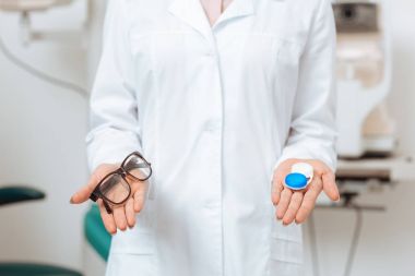 gözlük ve Kontakt lens klinikte holding beyaz paltolu optometrist görünümünü kırpılmış
