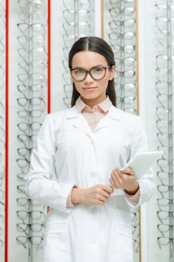 göz doktoru ile optik gözlük raf ile elinde tablet ile portresi