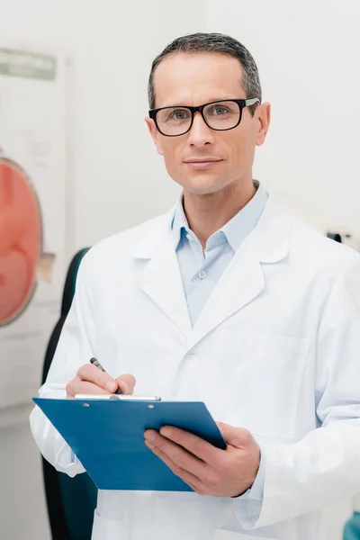 Portret Lekarza Notatnika Ręce Patrząc Kamery Klinice — Zdjęcie stockowe