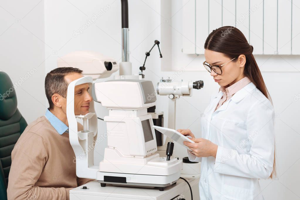 side view of patient getting eye examination in slit lamp in clinic
