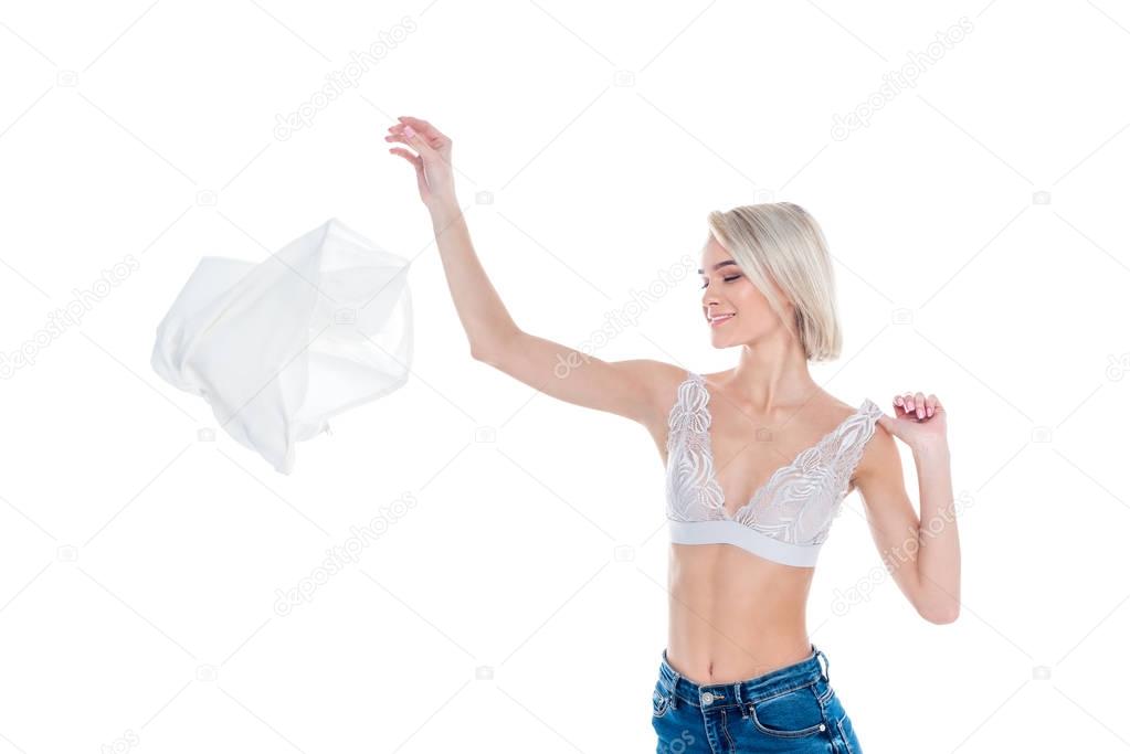 attractive sexy girl in bra throwing away clothes, isolated on white