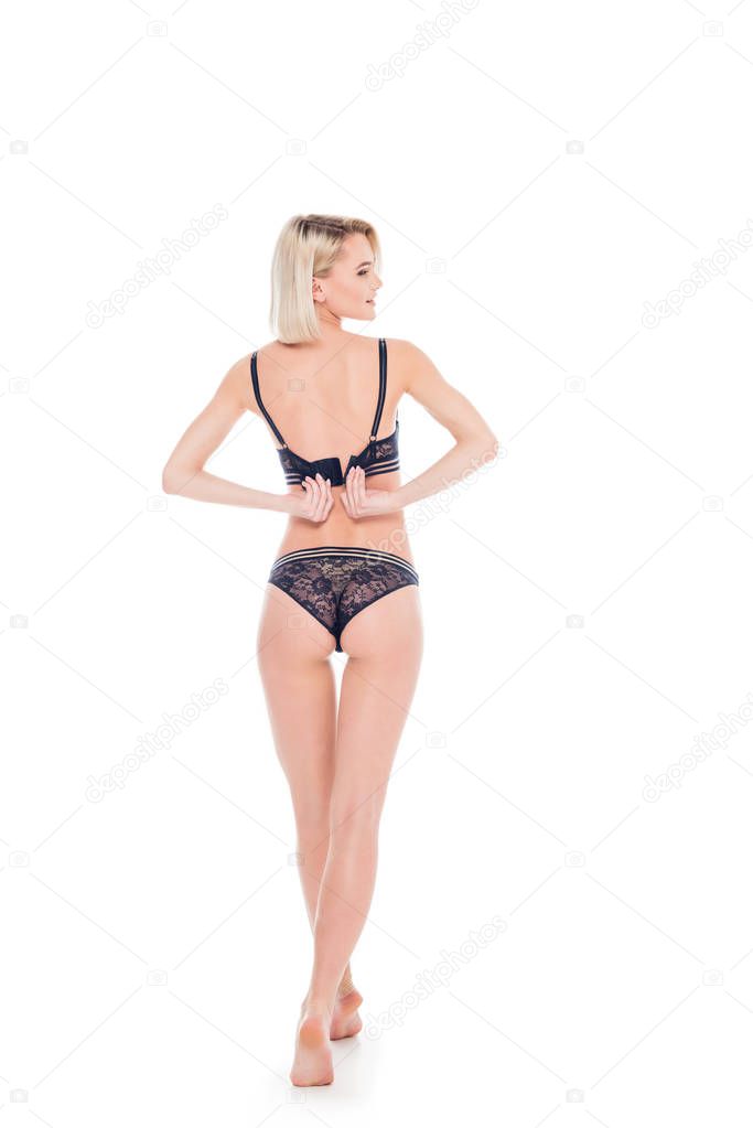 back view of beautiful sexy woman taking off black lingerie, isolated on white