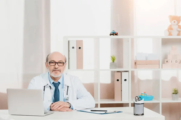 Portrait Senior Doctor Eyeglasses Looking Camera While Sitting Workplace Laptop — Stock Photo, Image