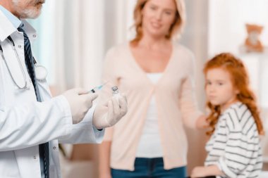 tıbbi şırınga gidiş eldivenlerle doktor Kliniği, küçük kız enjeksiyon yapmak için seçici odak