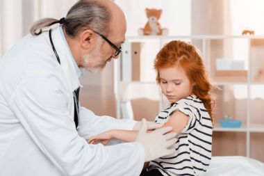 enjeksiyon Kliniği sonra hastalar kolunda alçı koyarak kıdemli çocuk doktoru