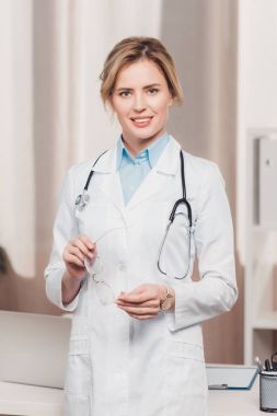 gözlük kamera Kliniği bakarak elinde ile gülümseyen doktor portresi