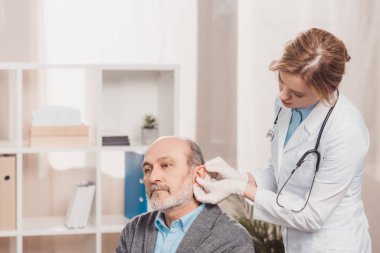 kadın doktor tıbbi hastada klinik kıdemli muayene eldivenleri