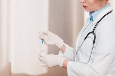 Beyaz önlük ve Medikal Ürünler şırınga enjeksiyon için klinik elinde tutan doktor kısmi görünümünü