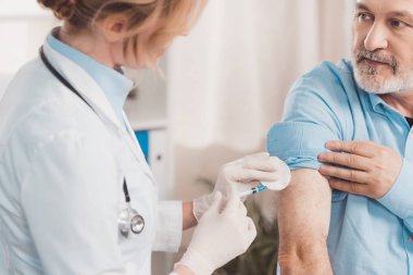 Beyaz önlük klinik kıdemli hastada enjeksiyon yapma doktor