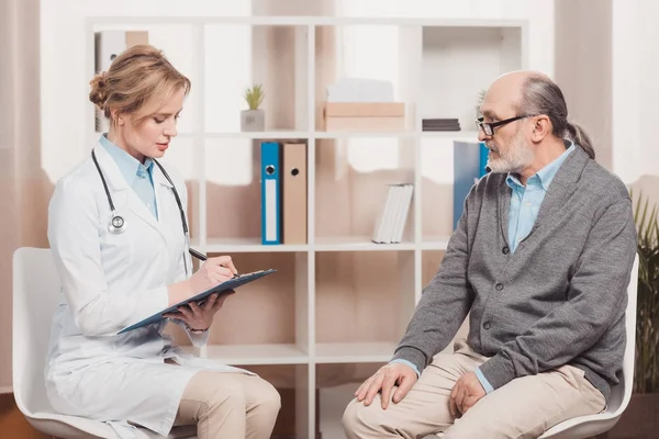 Arzt Weißen Kittel Mit Notizblock Hört Patienten Klinik — Stockfoto