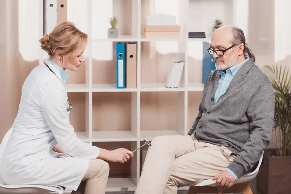 Boční Pohled Lékaře Vyšetřujícího Starší Pacient Reflexní Kladivo Klinice — Stock fotografie