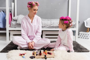 Anne ve kızı katta oturan kafasına saç silindirleriyle pijama