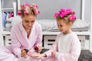 Lehçe onlar pijama saç Silindirler ile oturan kızının annesi boyama çivi