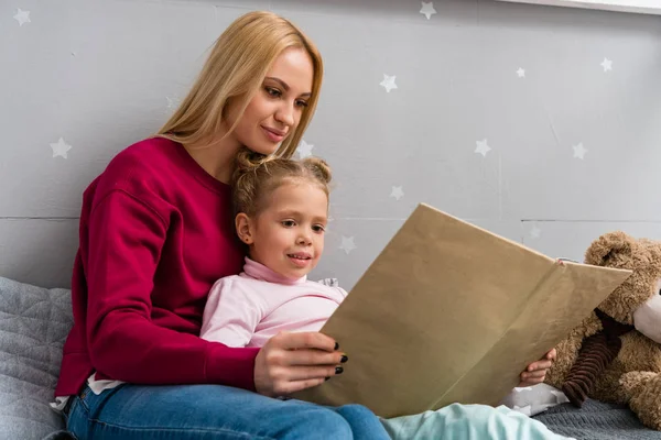 Young Mother Daughter Sitting Bed Reading Book Together — Stock Photo, Image