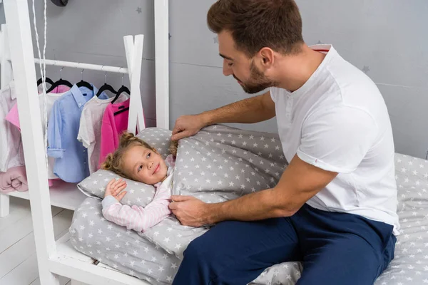 Padre Cubriendo Adorable Hijita Con Manta Cama — Foto de Stock