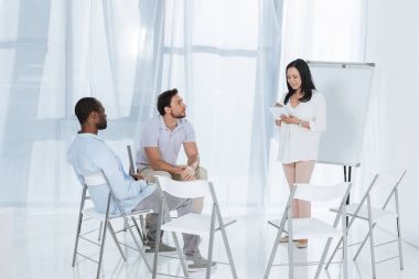 Orta gülümseyen koltuklarda oturan çok ırklı adam süre not defterinizdeki notlar alarak psikanalist yaşlı