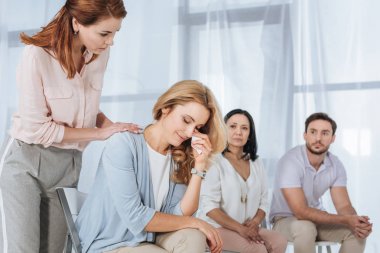 ağlayan kadın anonim grup terapisi sırasında destekleyen insanlar