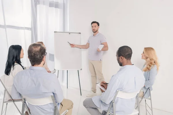 Männlicher Psychotherapeut Zeigt Auf Leeres Whiteboard Und Multiethnische Gruppe Von — Stockfoto
