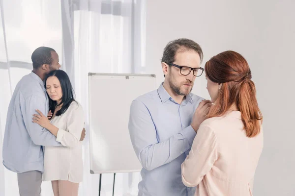 Dos Parejas Multiétnicas Pie Juntos Abrazándose Durante Terapia Grupo — Foto de Stock