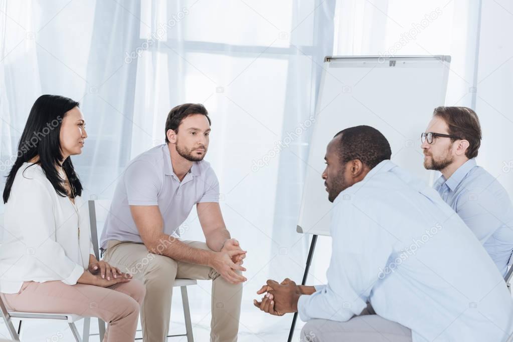 multiethnic middle aged people sitting on chairs during anonymous group therapy 