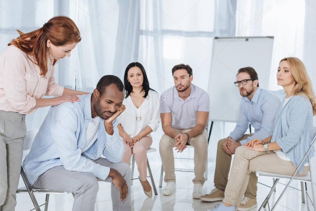 psychotherapist supporting african american man during group therapy