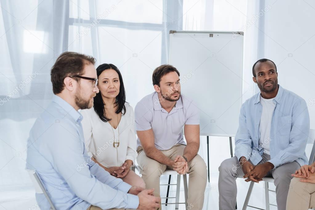 anonymous group of multiethnic middle aged people sitting on chairs during therapy