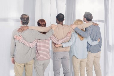 Dikiz ayakta ve grup terapisi sırasında kucaklayan çok ırklı insan 