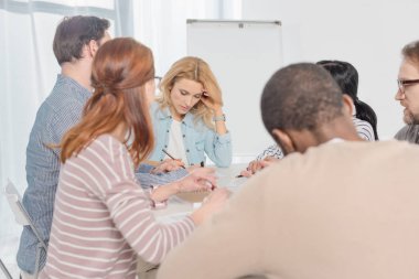 birlikte toplanan ve grup terapisi sırasında notlar almak çok ırklı insanlar