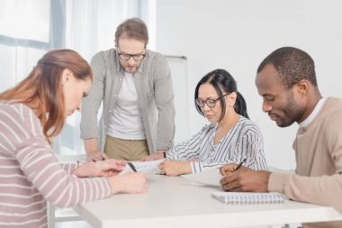 kağıtları ile birlikte çalışan çok ırklı orta yaşlı iş adamları