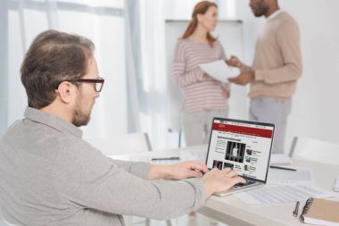 bbc haber sitesi ekranında Office ile dizüstü bilgisayar kullanarak gözlük içinde orta yaşlı adam