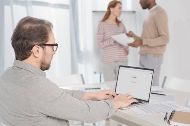 google web sitesi Office ekranda ile dizüstü bilgisayar kullanarak gözlük içinde orta yaşlı adam