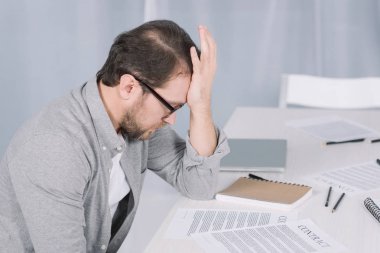 Office belgeleriyle masada oturan depresif overworked işadamı