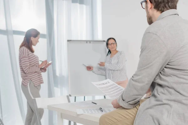 Asiatiska Affärskvinna Pekar Whiteboard Medan Kollegor Anteckningar Och Hålla Kontrakt — Gratis stockfoto