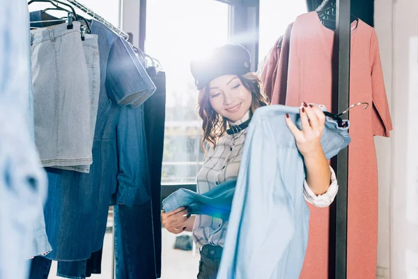 Улыбающаяся Молодая Женщина Ищет Новую Одежду Магазине — Бесплатное стоковое фото