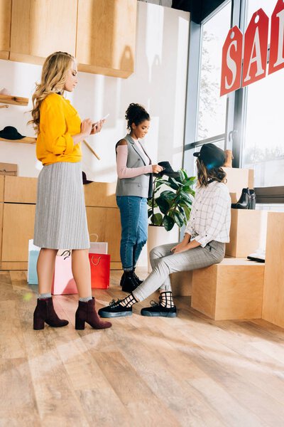 group of young shopping buddies spending time in clothing store