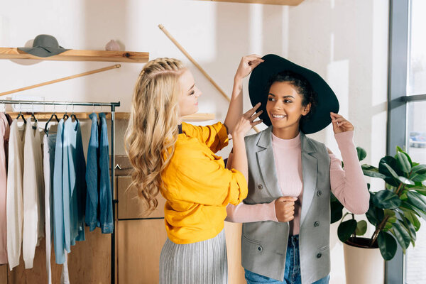 young stylish shopping buddies spending time in clothing store