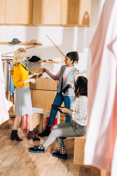 group of young women on shopping in shoes and clothing store