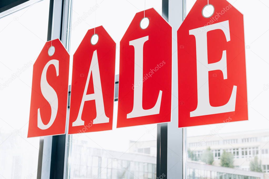 sale sign made of tags with letters on windows of boutique