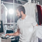 Dry cleaning worker using computer at warehouse