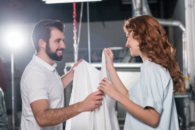Kuru Temizleme işçiler depoda beyaz kumaş katlama