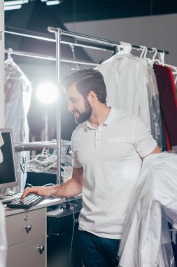 depoda bilgisayarla Kuru Temizleme işçisi