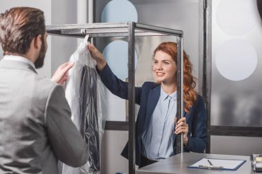 mutlu genç Kuru Temizleme açamayacağını vererek müşteri için giyim çanta