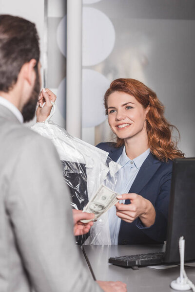 dry cleaning manageress taking cash for order from customer