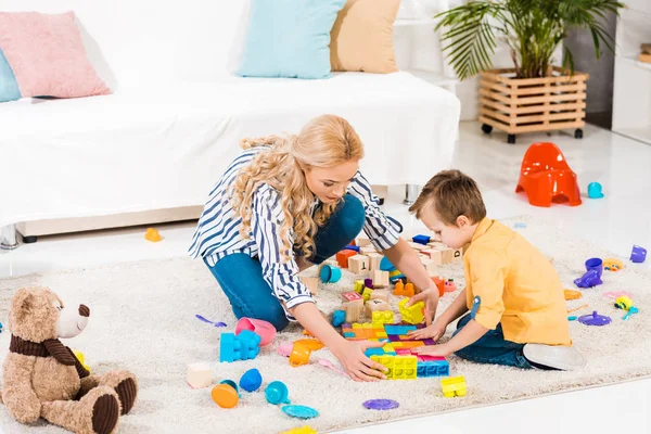 Focada Mãe Filho Brincando Com Brinquedos Juntos Chão Casa — Fotografia de Stock