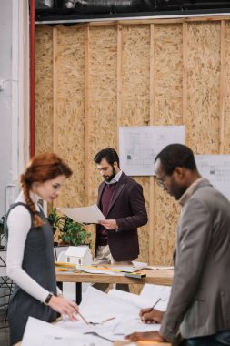 takım birlikte kontrplak dekor ile modern ofisinde çalışan mimarlar