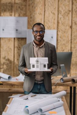 Genç Afro-Amerikalı mimar ofis kağıt ev modeli ile