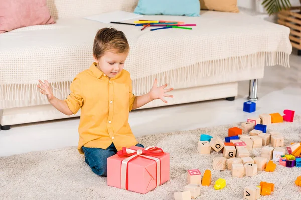 Surprised Boy Looking Gift Box Floor — Stock Photo, Image