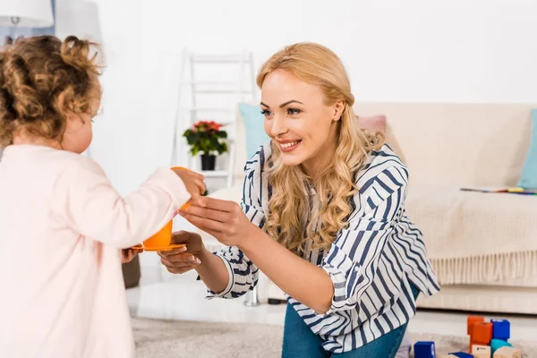 Sorrindo Mãe Dando Filha Brinquedos Plástico — Fotografia de Stock