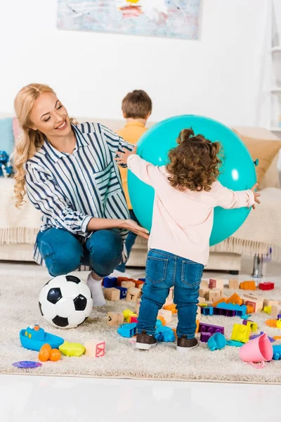 Anne ve kızı büyük hava topu tutmak gülümseyen