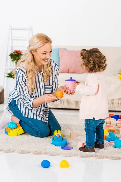 Lächelnde Mutter Und Tochter Beim Spielen Mit Plastikbechern — Stockfoto